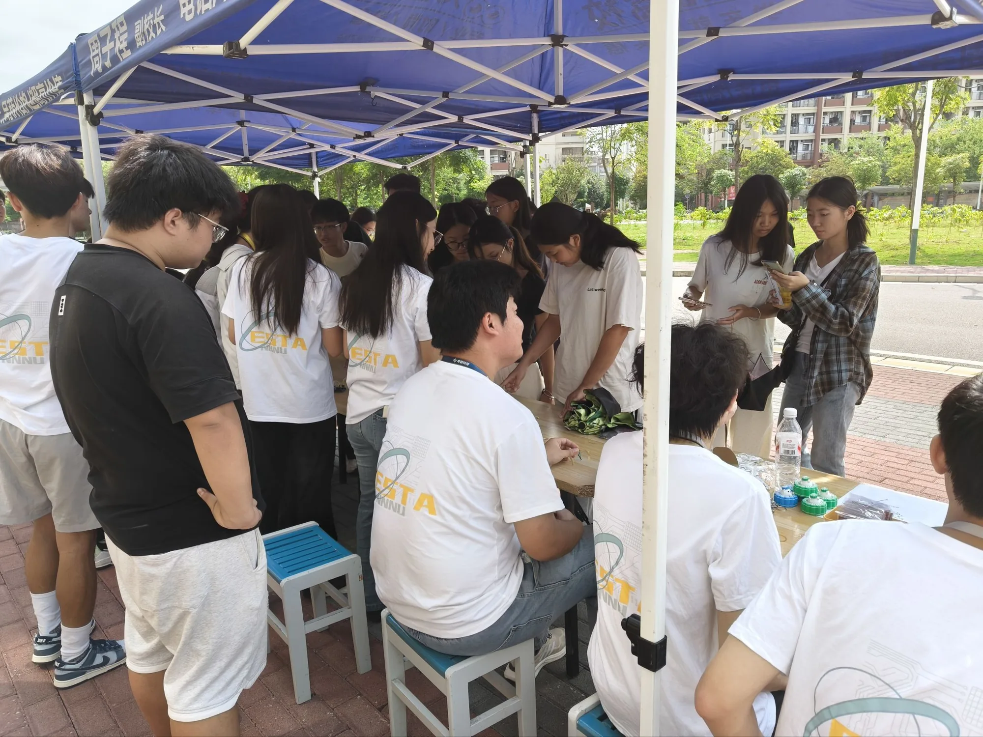 电子游园会活动中，学生在户外帐篷下交流