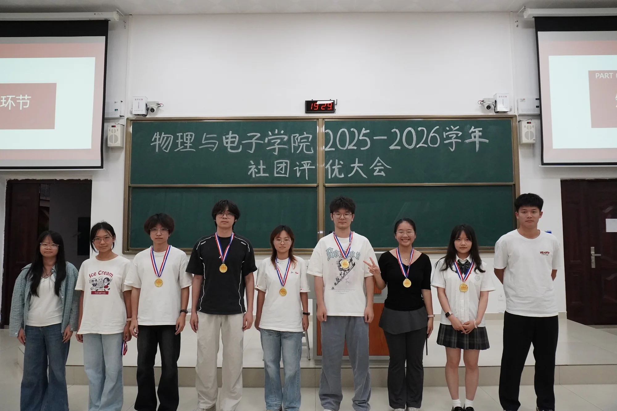 社团评优大会现场，参与者在讲台前合影